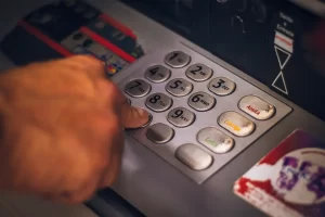 Ръка натиска бутони по клавиатурата на банкомат